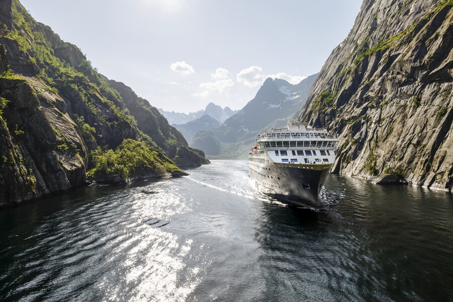 MV Northern Curiosity beneath steep Norwegian fjords